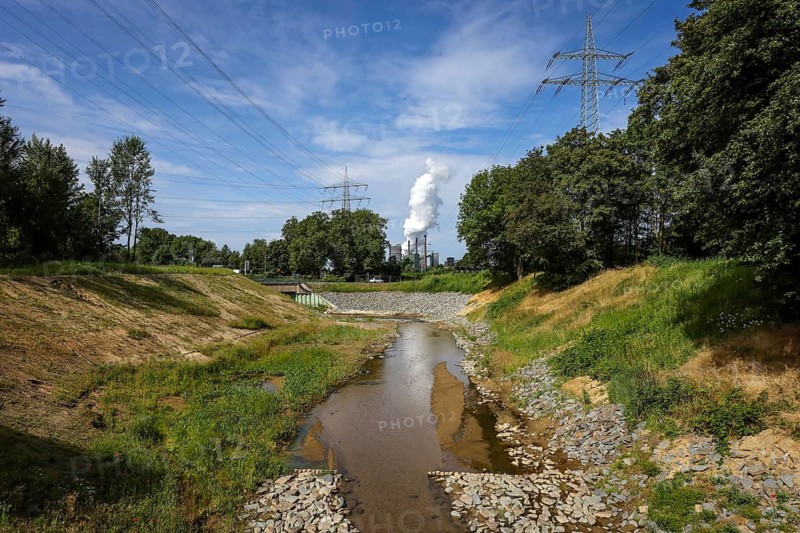 Bottrop, North Rhine-Westphalia, Germany, Renaturalised Boye, the tributary of the Emscher, was transformed into a near-natural watercourse, flood protection through newly designed flooding areas, the Boye is now free of wastewater after the construction of a parallel sewer, is part of the Emscher river system and thus part of the Emscher conversion, was previously an open, above-ground wastewater channel, mixed water channel with surface water and wastewater. At the back Prosper coking plant, ArcelorMittal Bottrop