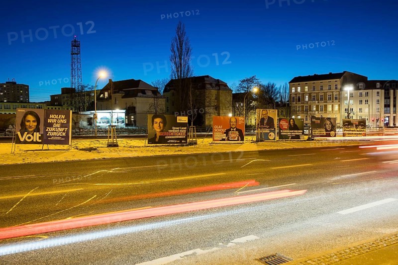 Election posters of the parties Volt, BSW, SPD, CDU, Bündnis 90/Die Grünen and FDP behind the lights of passing cars on the Nuthe-Schnellstraße in Potsdam for the election to the 21st Bundestag on 23 February 2025, taken on 19 February 2025