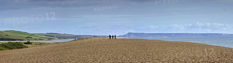 Fleet Lagoon at Abbotsbury and tourists walking on Chesil Beach tombolo, one of three major shingle structures in Britain along the Jurassic Coast, Dorset, southern England, UK