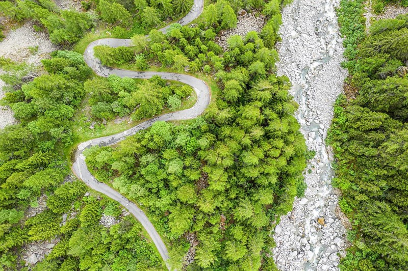 Aerial view, drone shot, windy road along a river, mountain valley, Switzerland