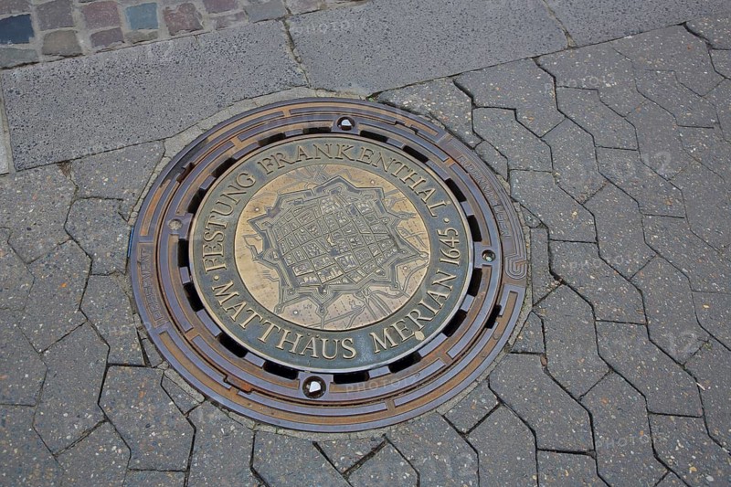 Round manhole cover with inscription fortress and memorial to engraver Matthäus Merian 1645, city history, relief, cast, paving stones, Frankenthal, Rhineland-Palatinate, Germany