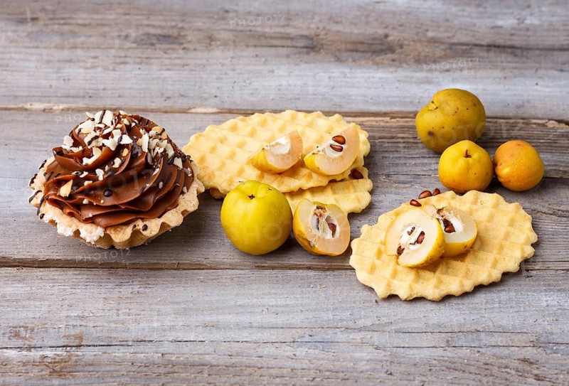 Sweet waffle and cake with cream on a rustic wooden background
