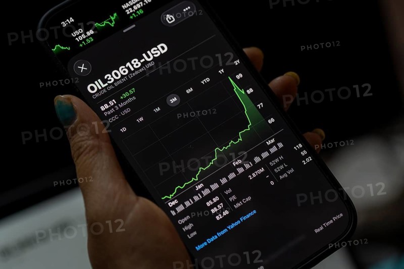 In this photo illustration, a person looks at a smartphone displaying Brent crude oil prices in USD, in Guwahati, India, on March 11, 2026. Oil prices reversed course from recent highs, slipping to around 90 USD a barrel after remarks by U.S. President Donald Trump on the Iran conflict. Markets remain unsettled as traders monitor the evolving geopolitical situation