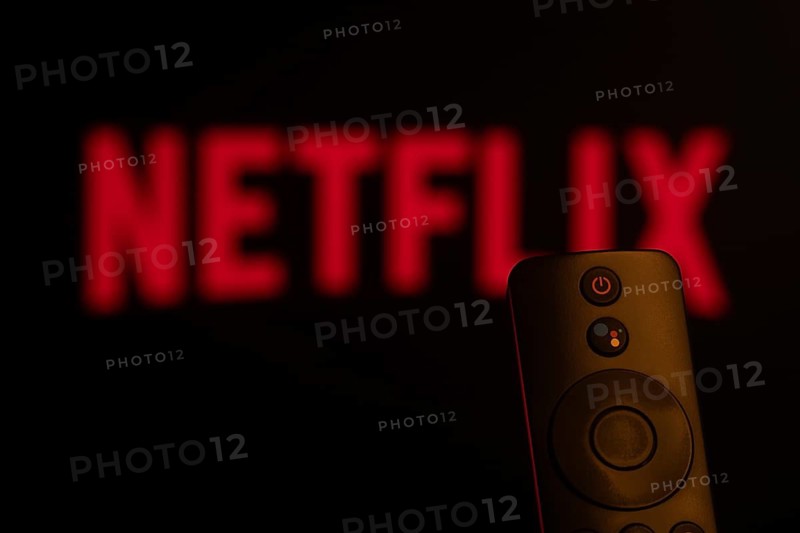 Dhaka, Bangladesh- 21 Jan 2026: Close-up of a smart TV remote control against a blurred Netflix logo