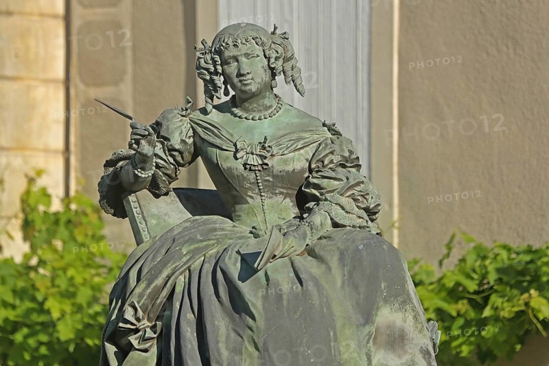 Monument with sculpture of Marquise de Sévigné, Madame, French, aristocracy, noblewoman, seated, historical, dress, gown, skirt, baroque, pen, writer, author, Sevigne, Place Sévigné, Grignan, Drôme, Tricastin, Provence, France