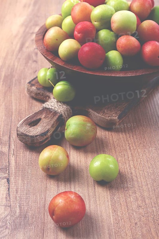 Cherry plum tkemali, fruit, plum variety, in a wooden plate, Georgian cuisine, top view, no people