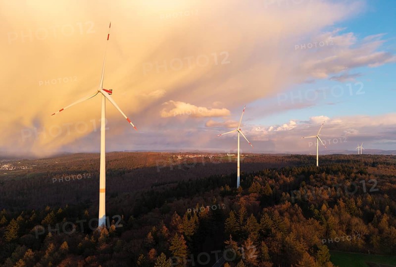 Wind turbines over a wooded hill at dusk, dramatic clouds in the sky, near Schorndorf-Winterbach, Baden-Württemberg, Germany