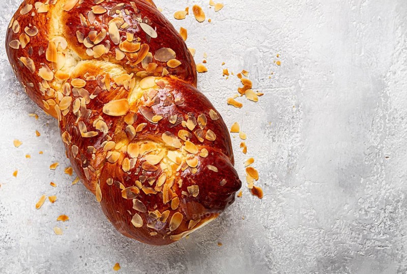 Braided, sweet bread pie, with sliced almonds, breakfast, braided bread, brioche, on a light background, top view, no people
