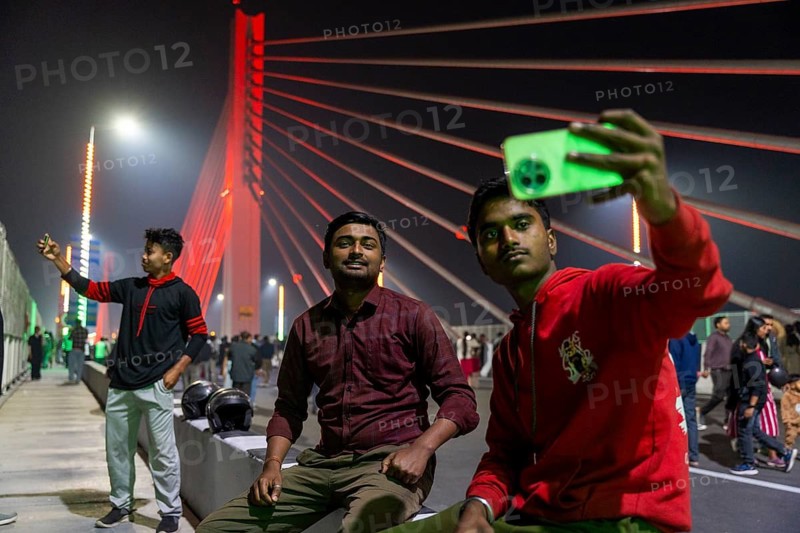 Young men take selfies on the newly inaugurated Kumar Bhaskar Varma Setu, a six-lane cable-stayed bridge over the Brahmaputra River, in Guwahati, India, on 15 February 2026