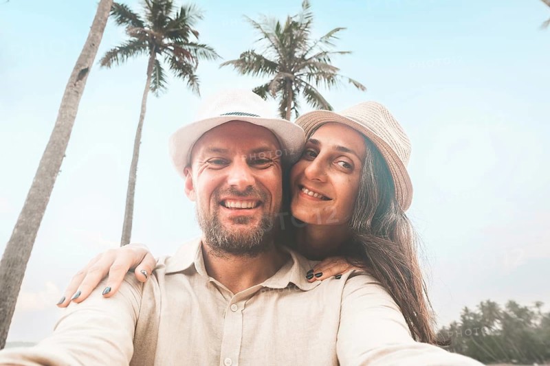 Young happy couple visit coconut island pose happy face taking holiday photo selfie in Sri lanka, Mirissa. People on holiday lifestyle concept