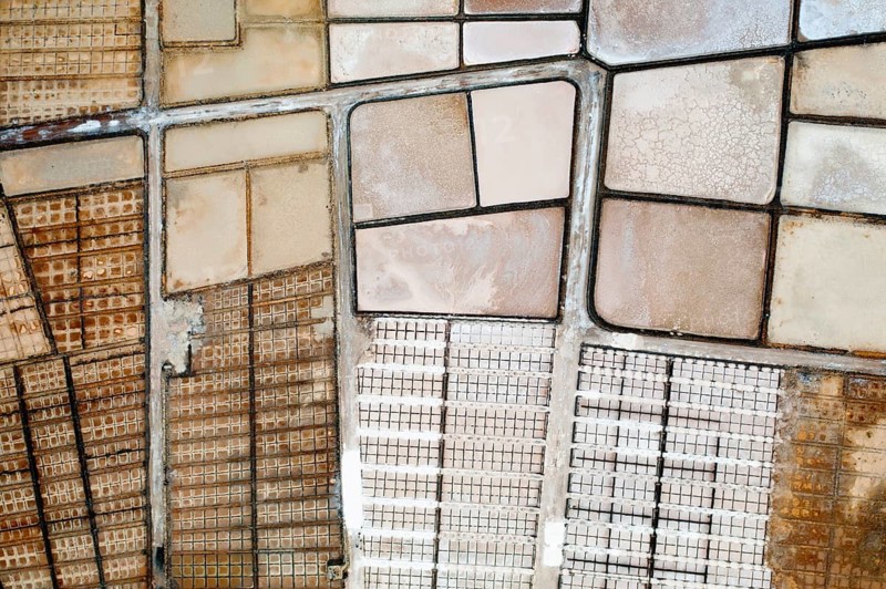 Overhead shot of salt evaporation ponds with varied textures and colors at Los Salares de Janubio in Lanzarote, capturing the geometric beauty of salt production