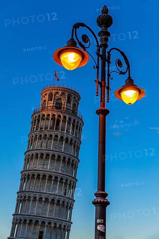 The Leaning Tower under an illuminated street lamp in the evening light, Pisa, Tuscany, Italy
