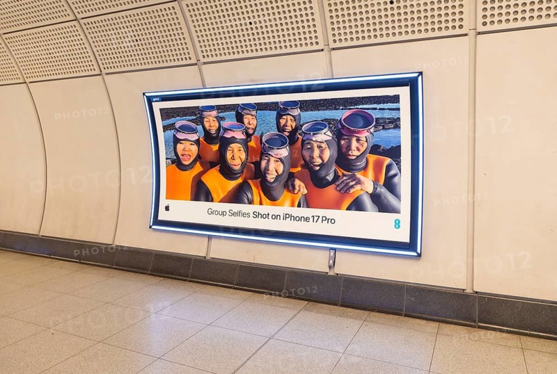 Advertising poster for Group Selfies Shot on iPhone 17 Pro, Transport for London (TfL) underground train station, London, England, UK