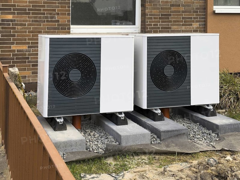 2 heat pumps are installed on an apartment block in a front garden, Hilden, Germany