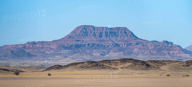Mountains in a barren desert landscape, silhouettes against the light, Damaraland, Kunene, Namibia
