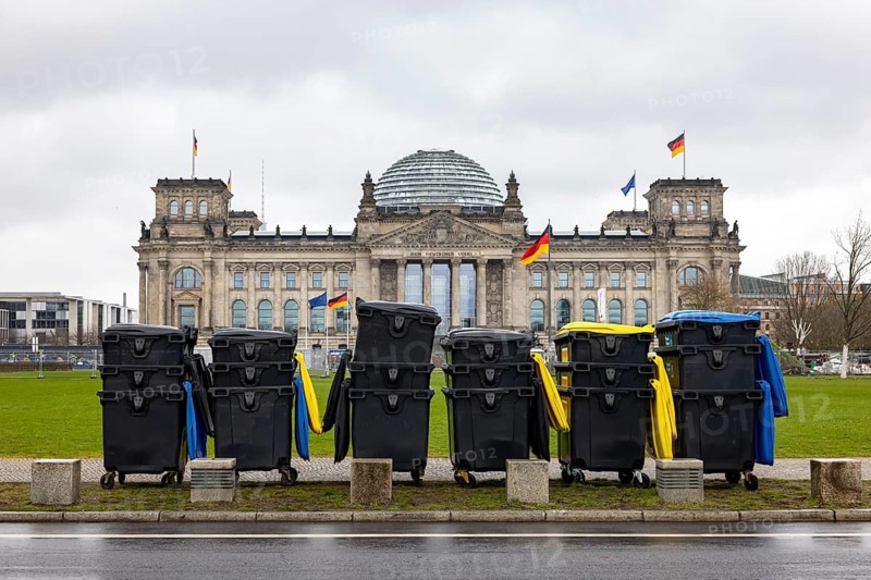 Reichstag Berlin with waving German flags. There are dumpsters from a major event in front of it. Berlin, Germany