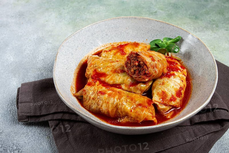 Stuffed cabbage rolls with minced meat, in tomato sauce, top view, without people, in the spotlight.