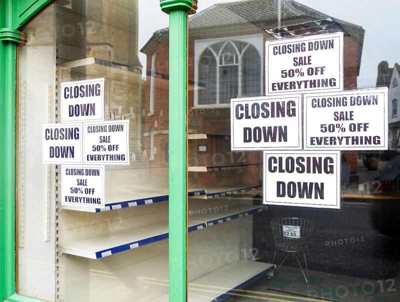 Shop window signs with empty shelves closing down sale, Beccles, Suffolk, England, UK