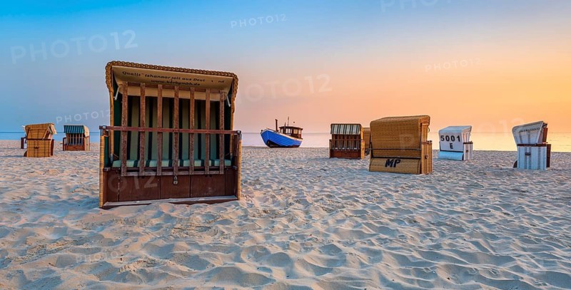 Beach chairs and fishing trawlers on a fine sandy beach at sunrise, Baltic resort Heringsdorf, Usedom island, Mecklenburg-Western Pomerania, Germany