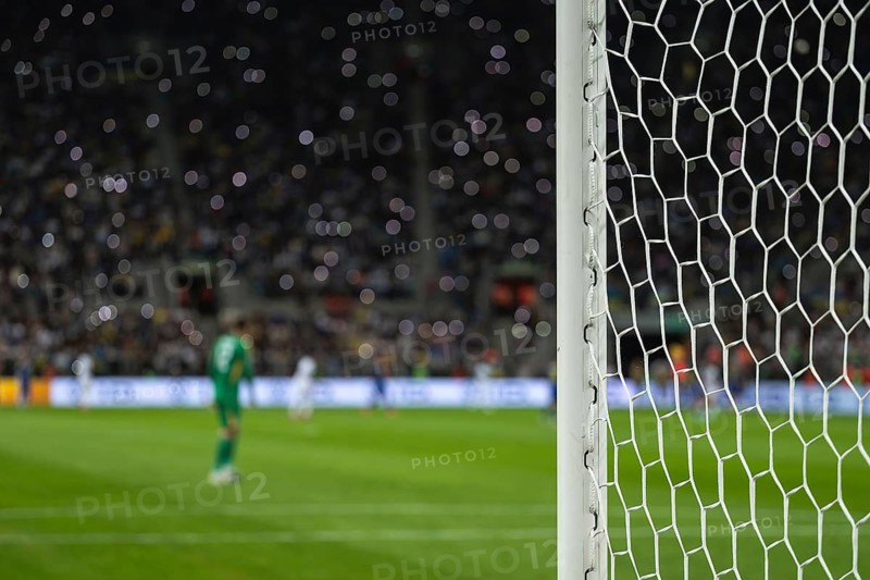 Detail of goal's post with net and football player during match in Wroclaw, Poland