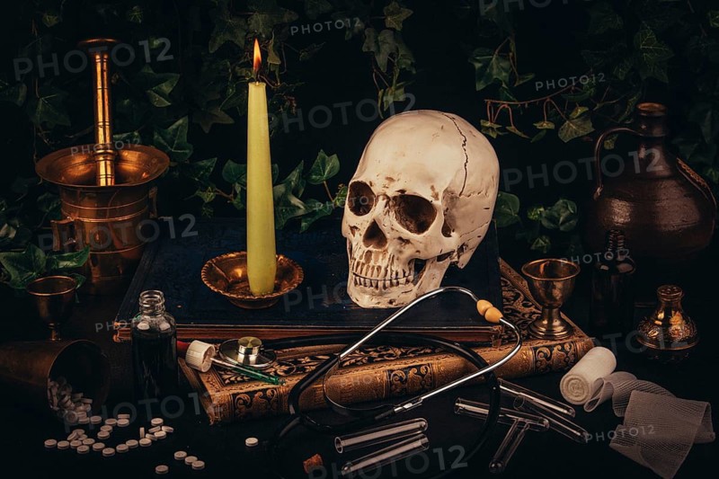 A skull with a candle on antique books, framed by medical tools in a dark atmosphere