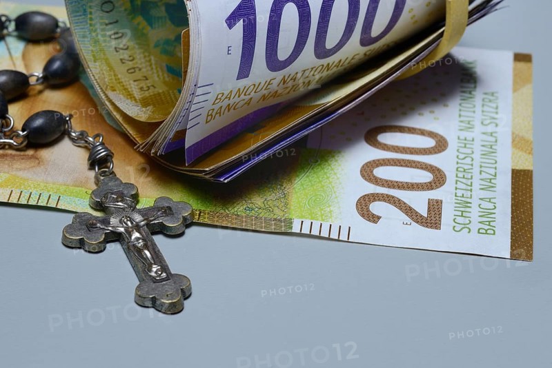 Crucifix and banknotes, Swiss francs, church and money