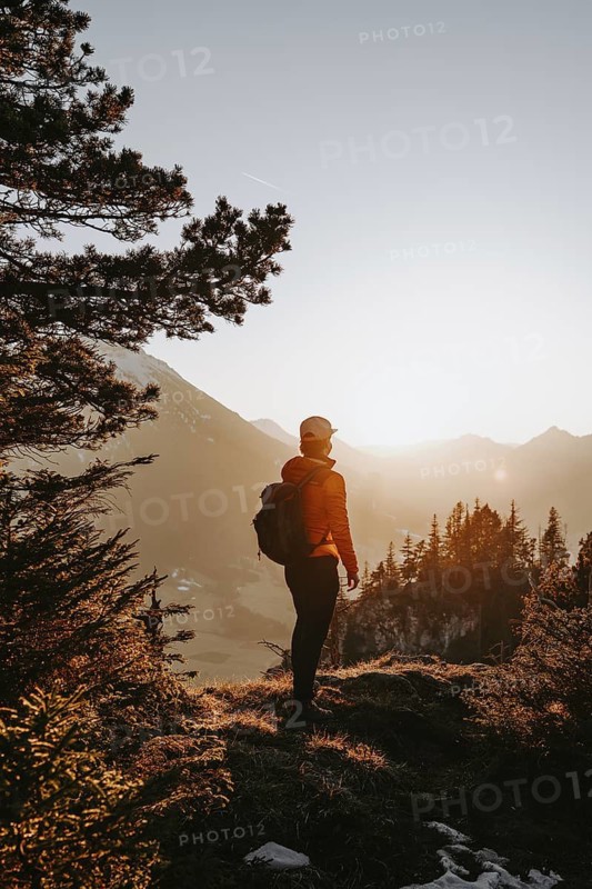 Hiker in the Allgäu at sunset in spring on the Zirmgrat near Pronten in the Allgäu