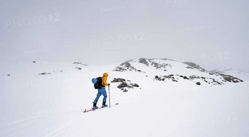 Ski tourers in a wintry mountain landscape with cloudy mountain peaks, ascent to Piz Laviner, Grisons Haute Route, Albula Alps, Rhaetian Alps, Grisons, Eastern Switzerland, Switzerland