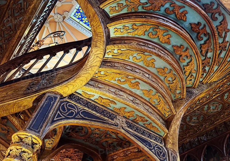 Livraria Lello, interior view of the Lello bookstore with rich decorations of the curved wooden staircase from below, Porto, Portugal