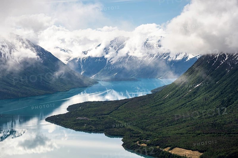 View of snowy mountains in spring and turquoise Kenai Lake with reflection, Slaughter Ridge Trail, Cooper Landing, Kenai Peninsula, Alaska, USA