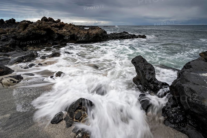 Waves blaze on the beach, rocky coast with volcanic stones, long exposure, Playa de la Pequeña, Punta Usaje, Lanzarote, Canary Islands, Spain