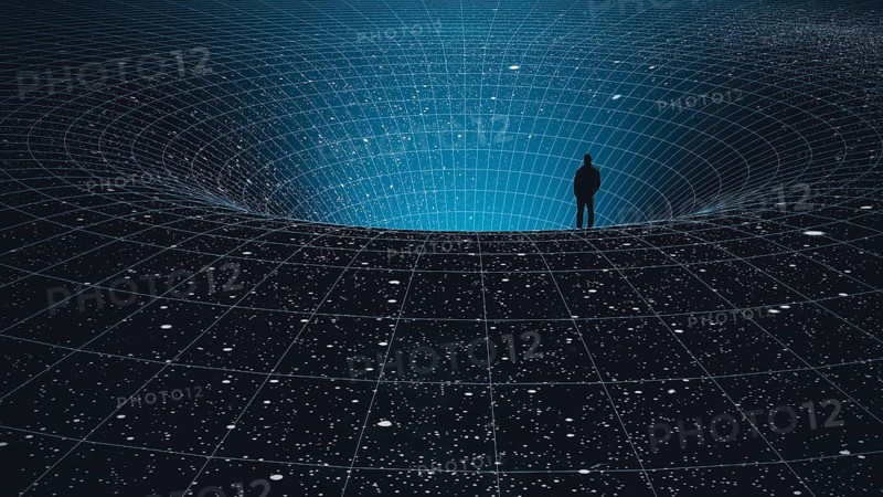 A man stands at the edge of a black hole, gazing into the depths of the universe, surrounded by stars in a mesmerizing cosmic abyss