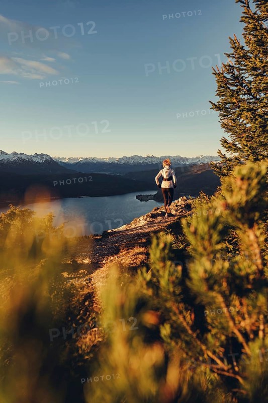 Trail running in autumn on the Jochberg on Lake Walchensee against the wonderful backdrop of the Alps, Bavaria, Germany