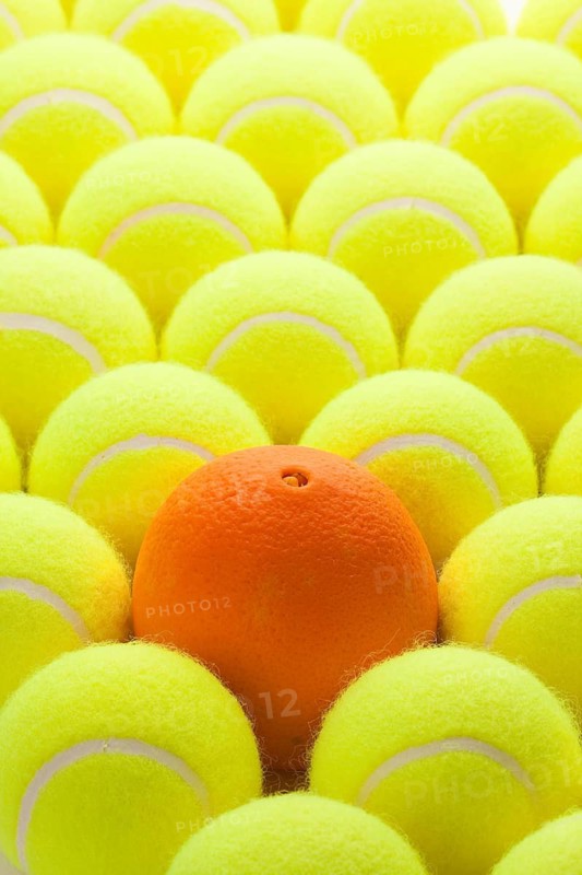 Macro Set of Brand New Tennis Balls and One Orange