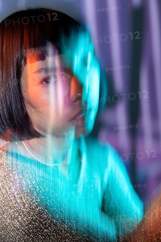 A futuristic Latin woman emerges with vibrant neon lights, blurring the lines of digital and reality. This captivating image embodies the essence of the metaverse