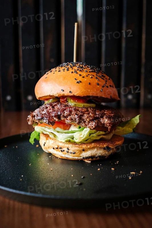 Mouthwatering hamburger served in a cozy restaurant setting. The juicy beef patty topped with fresh lettuce, tomato, and pickles, all encased in a seeded bun, promises a delightful meal experience, Palma, Islas Baleares, España