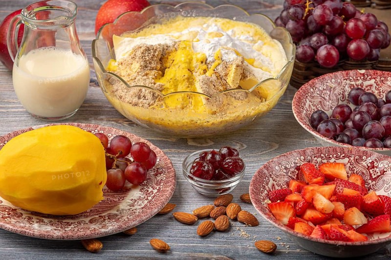 Apple, grapes, mango and strawberries next to a bowl of baking ingredients
