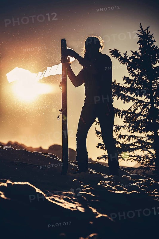 A woman's ski tour at sunrise on the Tegelberg in the Allgäu in the Ammergebirge, Bavaria, Germany