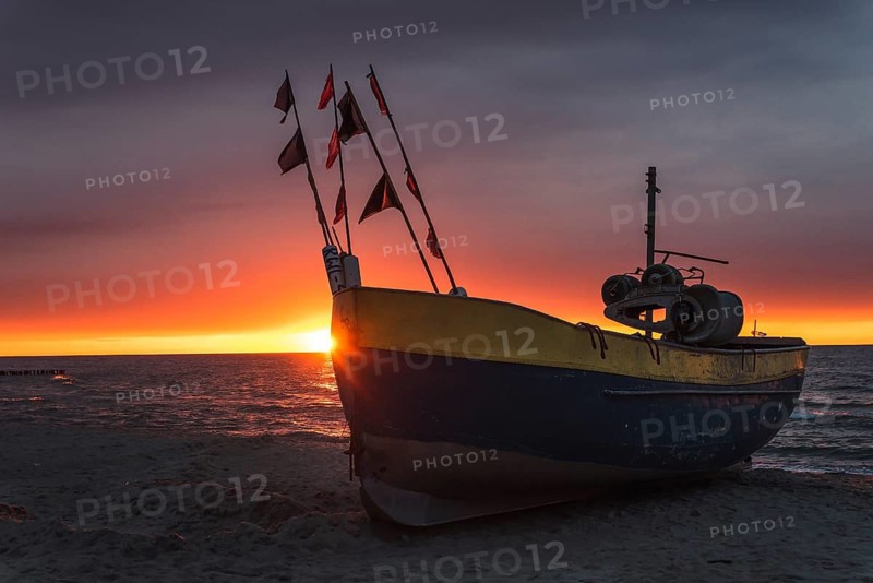 Fishing boat on the beach at sunset. Baltic sea