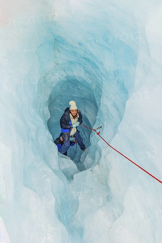 Mountaineer moving up ice cave, Fox Glacier, Westland National Park, South Island, New Zealand