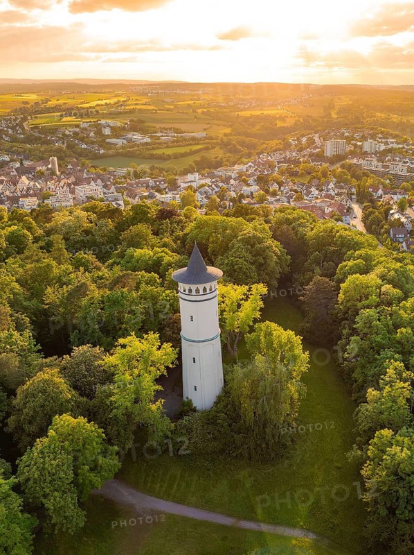 Tower surrounded by dense forest at sunset with a view of a village, Engelberg Tower, Leonberg, Germany