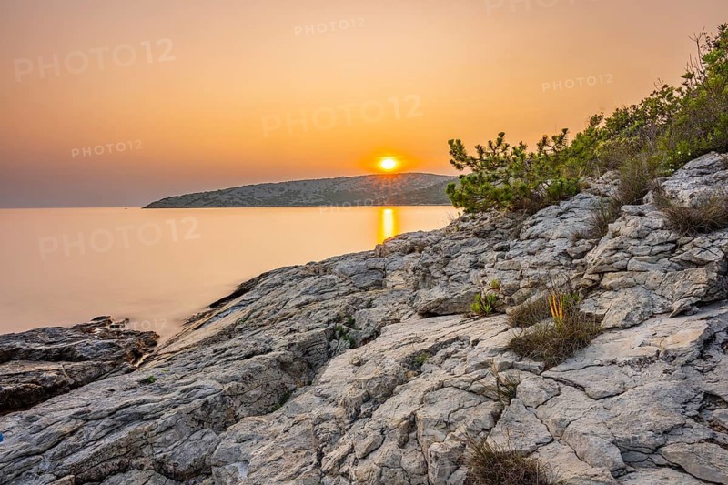 Sunset over crystal clear water on the beach of Ustrine Bay on the island of Cres, long exposure, Croatia