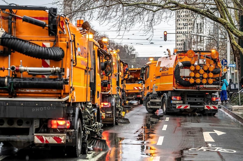 Sweeping on Rose Monday in Düsseldorf, the municipal utilities clean up after the train, confetti, camels, trash, employees with sweepers from AWISTA, Society for Waste Management and City Cleaning, central disposal and urban cleaning companies in Düsseldorf, clean the train's path with their street cleaning machines, North Rhine-Westphalia, Germany