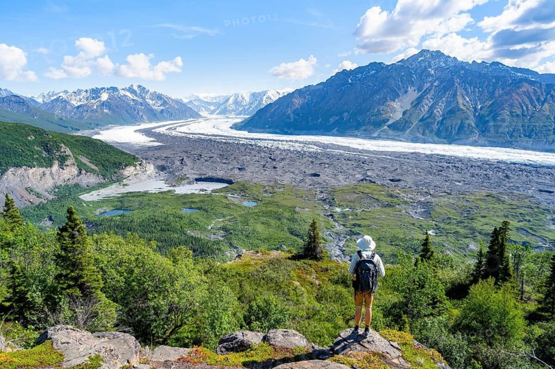 Young man enjoying the view, view of impressive mountain landscape with Matanuska glacier and glaciated mountain peaks, Lion's Head, Chugach Mountains, Alaska, USA