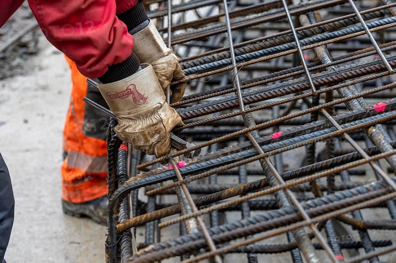 Assembly of reinforcing steel for the reinforced concrete foundation of a wind turbine, a mesh of rebar and reinforcing steel mesh, connecting the steel elements with binding wire, twisting with tongs, over 100 tons of reinforcing steel were used, the wind turbine will have a hub height of 160 meters, part of a new wind farm in Sauerland, near Balve, North Rhine-Westphalia, Germany