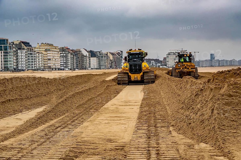 Bulldozers when distributing sand on the beach in the town of Knokke-Heist, part of coastal protection and beach maintenance, due to floods, erosion and sea level rise, the sand on the beach is repeatedly washed into the sea, in winter the sand from the seabed is washed back onto the beach with suction vessels, the excavators and levelers then distribute the sand back on the beach to eliminate the difference in height so as to bathe To make the beach usable again for the next season