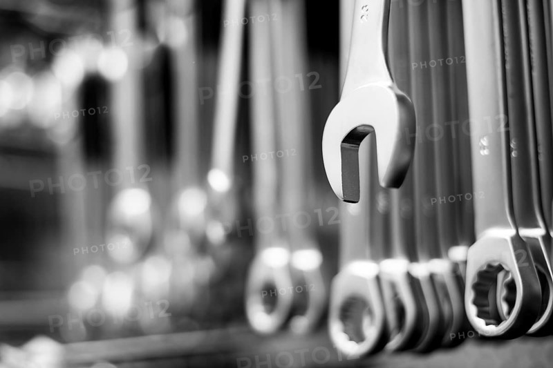 Hanging wrench with a lot of wrenches in background
