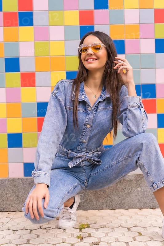 Young caucasian girl with a monkey cowboy in colored tiles. Enjoying the city on vacation, a young girl lifestyle with orange sunglasses, space copy and paste