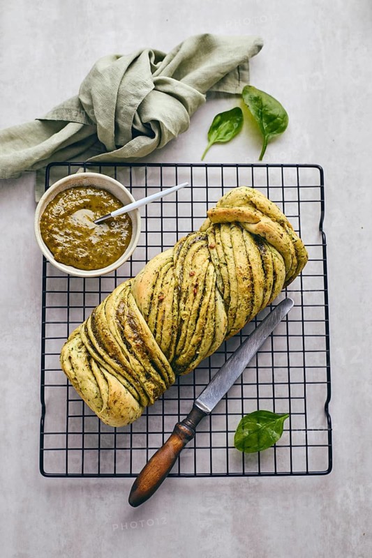 Baked homemade savoury babka plaited bread loaf flavoured with pesto