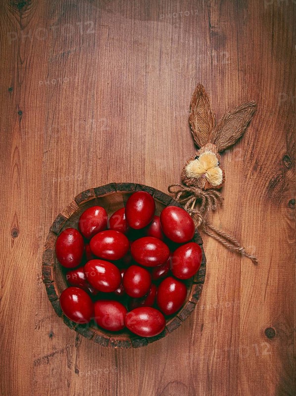 Painted eggs in a wooden bowl, red, painted madder dye, powder from the roots of endro, with onion husks, top view, Easter, Georgia